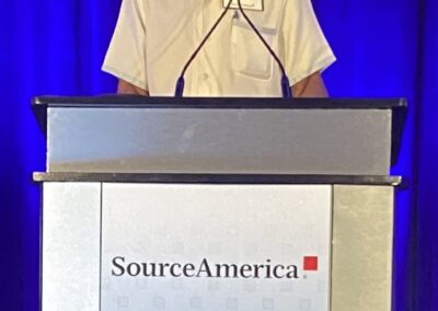 Simeon Fowler on stage at the Grassroots Conference behind the speaker podium