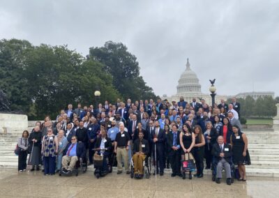 A large group of People with Disabilities who were invited to speak as self-advocates for the Grassroots conference standing on stairs outside the Capital Building Behind