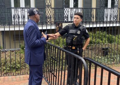 Simeon Fowler standing outside talking to a secret service officer while attending the 2025 Grassroots Conference