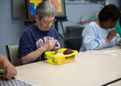 Female artist working with balls of yarn from a basket