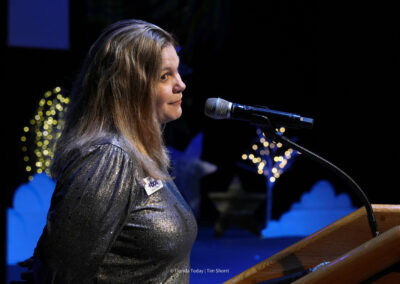 Keri Goff at the podium on stage at the BAC 12th Annual Performing Arts Showcase at the King Center in Melbourne.
