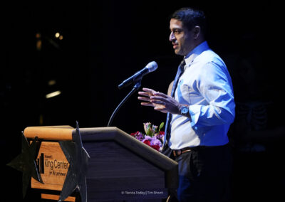 Amar Patel, BAC CEO and President speaking at the podium on the King Center stage at the 12th Annual Performing Arts Showcase.