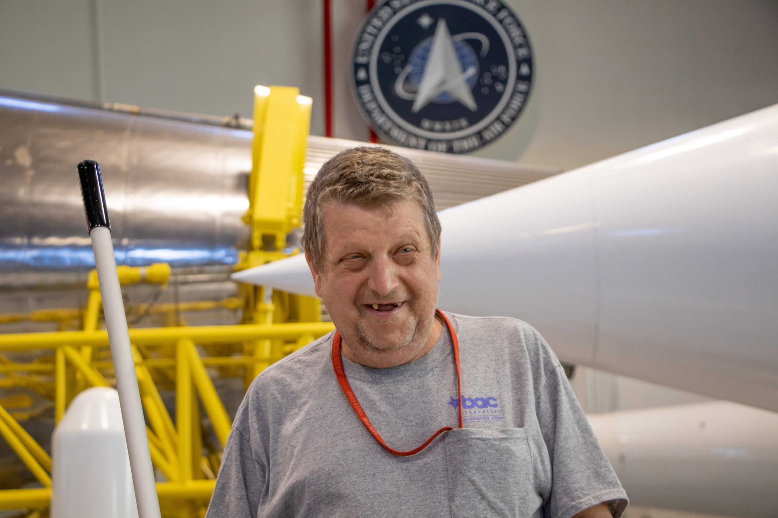 Custodian, James Fox, standing with Space Force Base Seal behind him