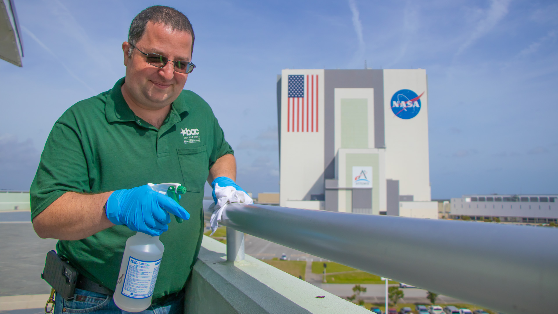 Custodian, Jeremy Herbert, cleaning railing at Kennedy Space Center Center