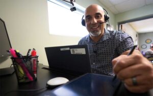 Call Center employee with headset entering information on tablet