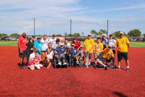 Groupd of people with all abilities pose on a baseball mound.