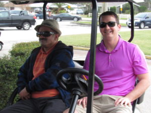 Nas and Tony sit in the golf car, relaxing between holes.