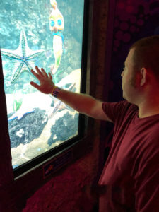 Justin uses a touchscreen device to learn about sea life.